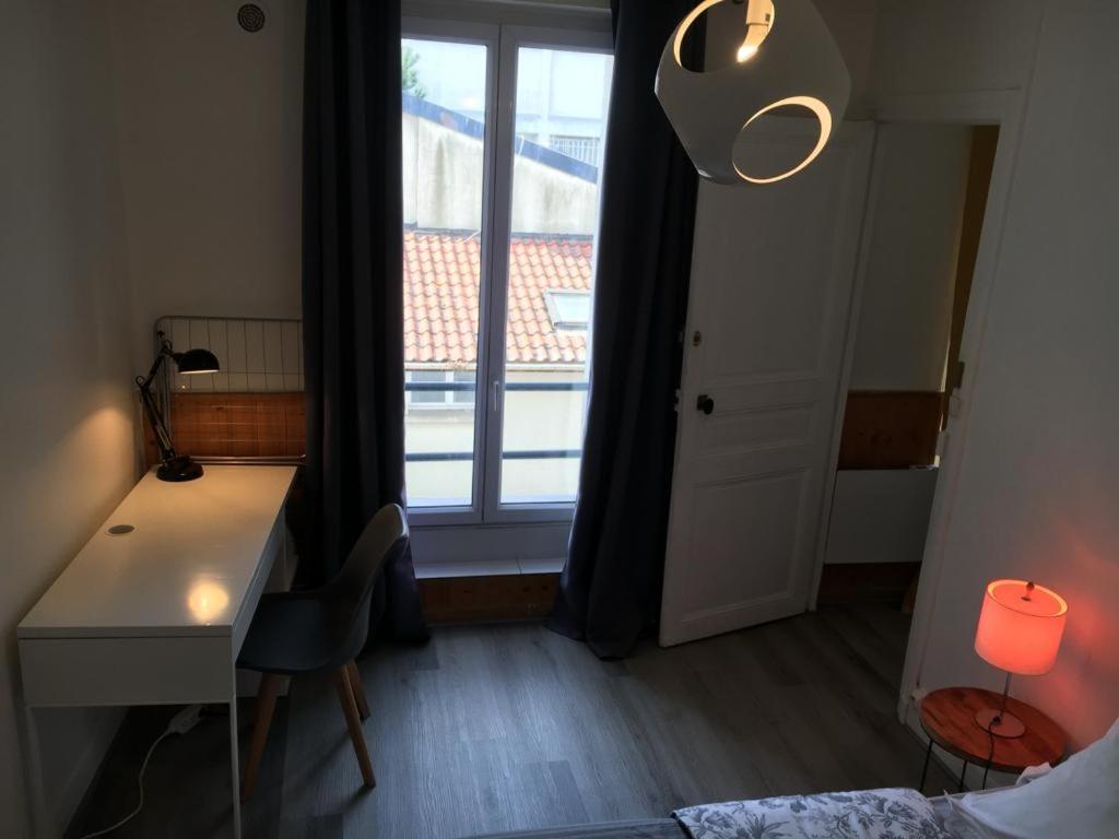 a room with a desk and a window with a deskablish at appartement T2 porte de Pantin Métro Hoche in Le Pré-Saint-Gervais