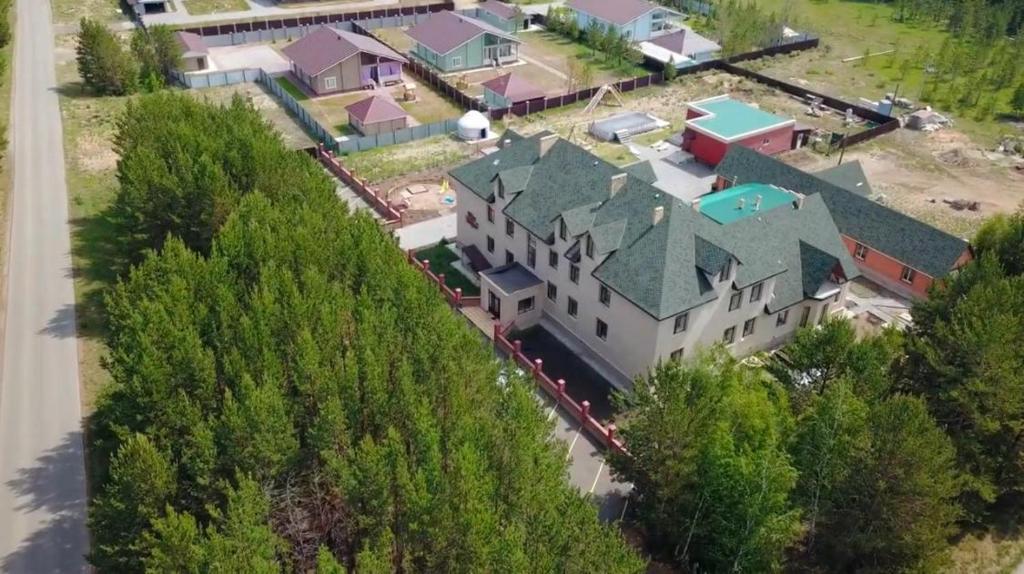 uma vista superior de uma casa grande com um telhado verde em Демалыс үйі Риза Гостевой дом em Vorobʼyëvka