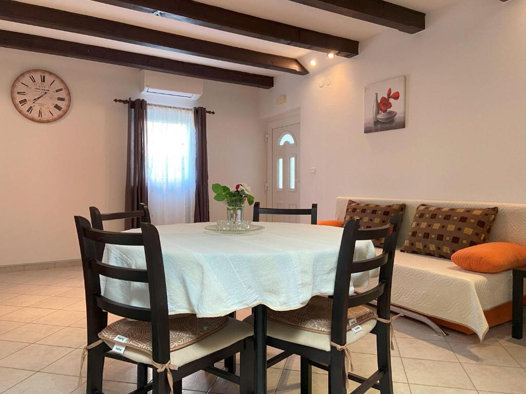 a dining room with a table and chairs and a clock at Apartment Ivan in Rovinj