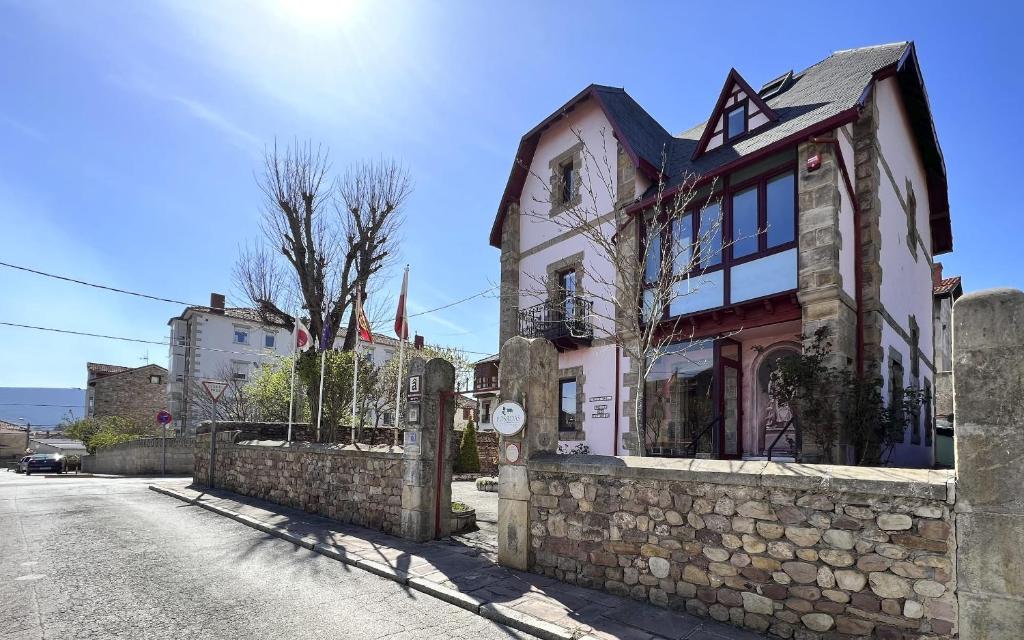 a stone building on a street with a stone wall at Posada Villa Rosa in Reinosa