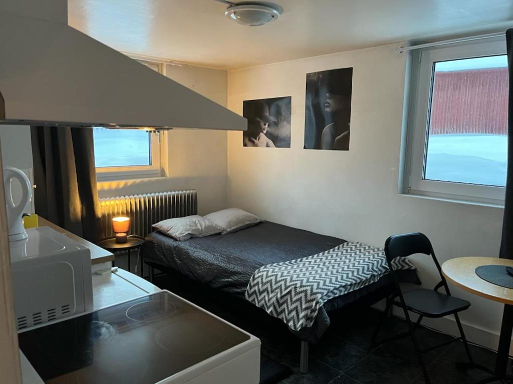 a small room with a bed and a desk and a kitchen at Apartment with shared bathroom in central Kiruna 1 in Kiruna