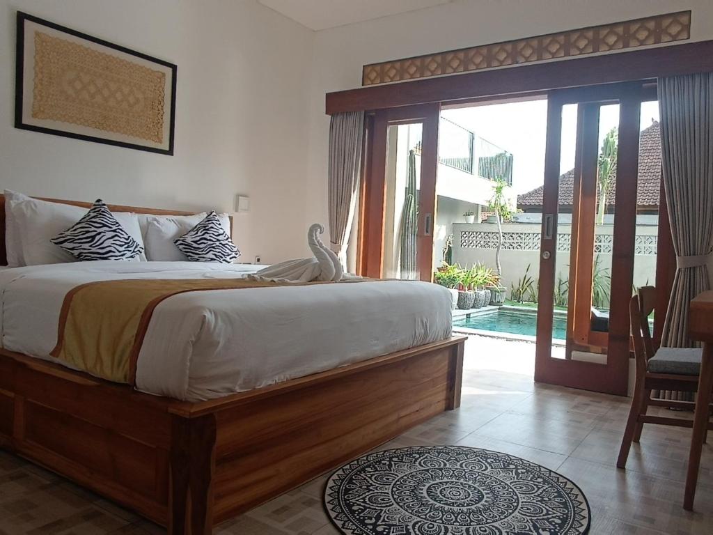 1 dormitorio con 1 cama y puerta corredera de cristal en The Breeze Stay and Surf Canggu Bali, en Canggu