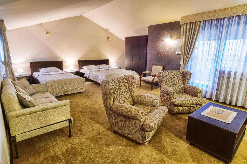 una habitación de hotel con 2 camas y una silla en Apartments & Rooms - Konak Vukasinovic, en Belgrado