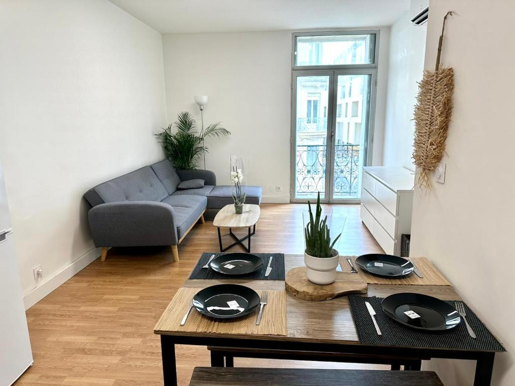 ein Wohnzimmer mit einem Tisch und einem Sofa in der Unterkunft Gare/comédie 6 personne neuf in Montpellier