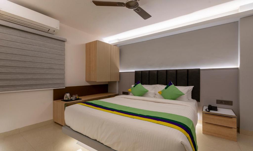 een slaapkamer met een groot bed met groene kussens bij Treebo Tryst D Consulate in Hyderabad