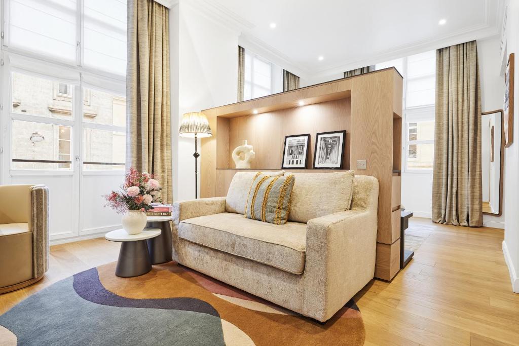 a living room with a couch and a table at Grand Hôtel Du Palais Royal in Paris