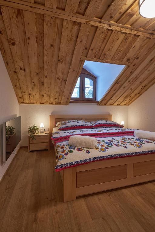 a bedroom with a large bed in a attic at Koliba pod Vlkolíncom in Ružomberok