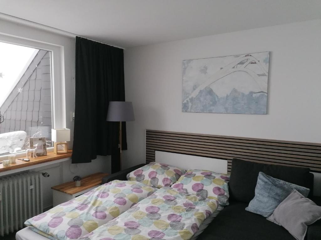 1 dormitorio con cama y ventana en Ferienwohnung Astenrefugio, en Winterberg