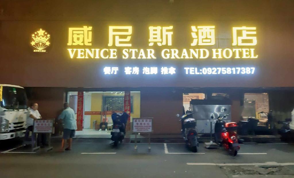 a sign for avenue star grand hotel with motorcycles parked outside at Venice Star Grand Hotel in Manila