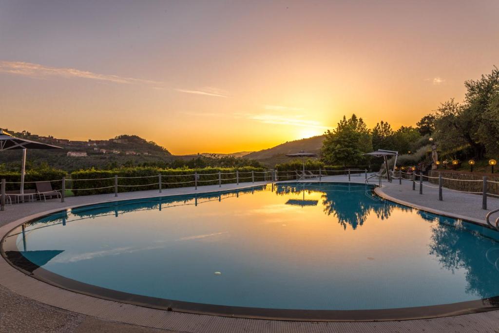 einen Pool mit Sonnenuntergang im Hintergrund in der Unterkunft Villa Olimpo - Homelike Villas in Pieve a Nievole