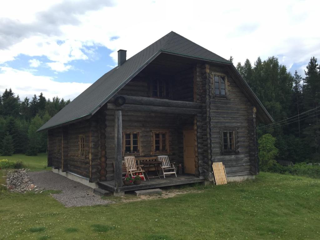 Cabaña de madera con 2 sillas y mesa en Vällamäe talu puhkemaja, en Haanja