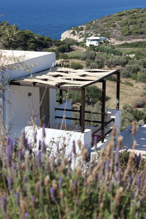 a building with a roof with the ocean in the background at Auberge Kalopetri in Kamiros
