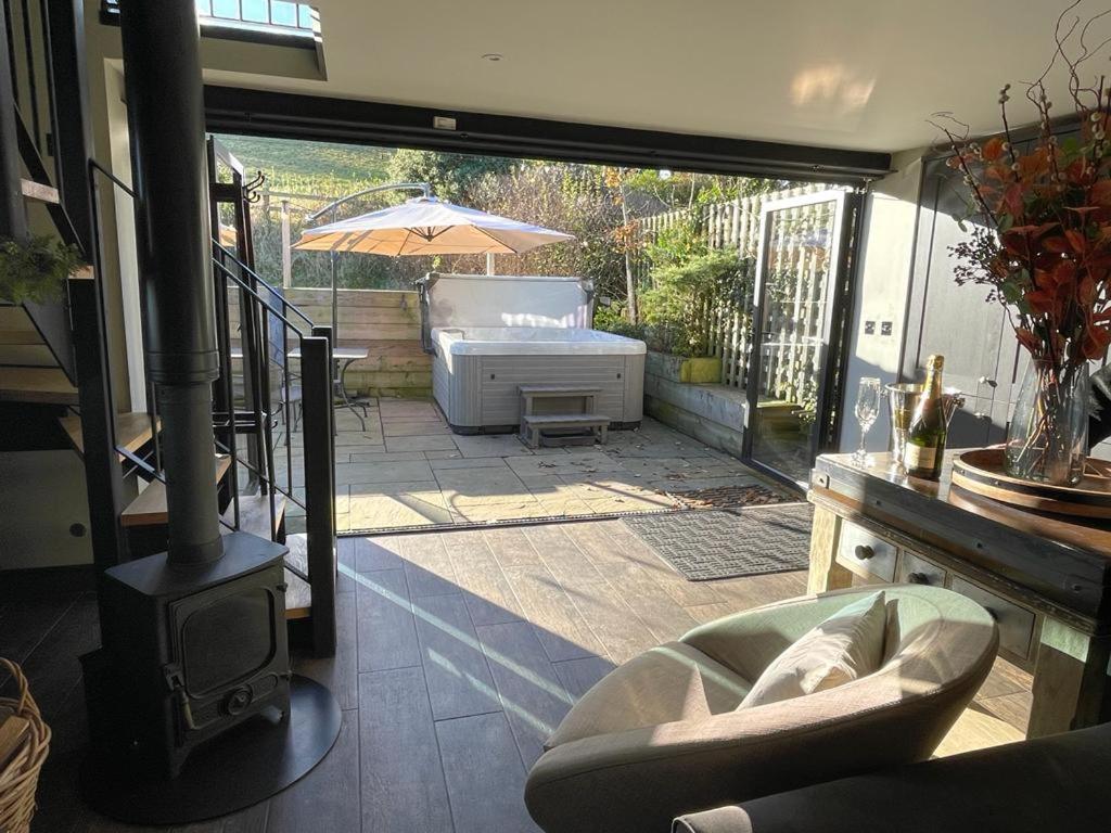 a living room with a view of a patio with a heater at Pass the Keys The Cosy Romantic and Elegant for 2 with Hot Tub in Hayfield