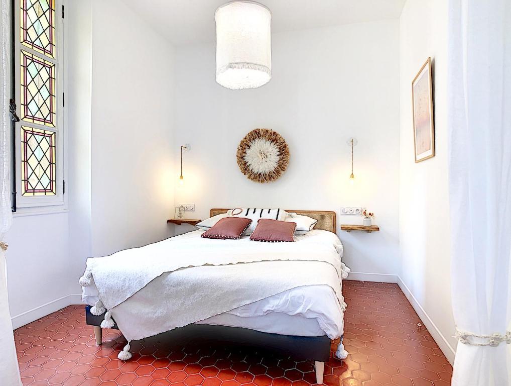 une chambre avec un lit dans une pièce blanche dans l'établissement - Maison ÛMA - Wifi, Netflix, Mer et Centre, à Marseille