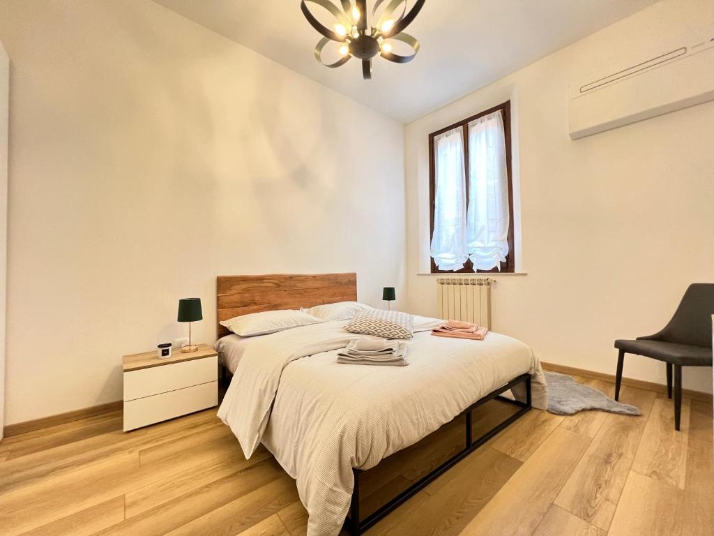 um quarto com uma cama, uma cadeira e uma janela em mazzini101apartment em Ferrara