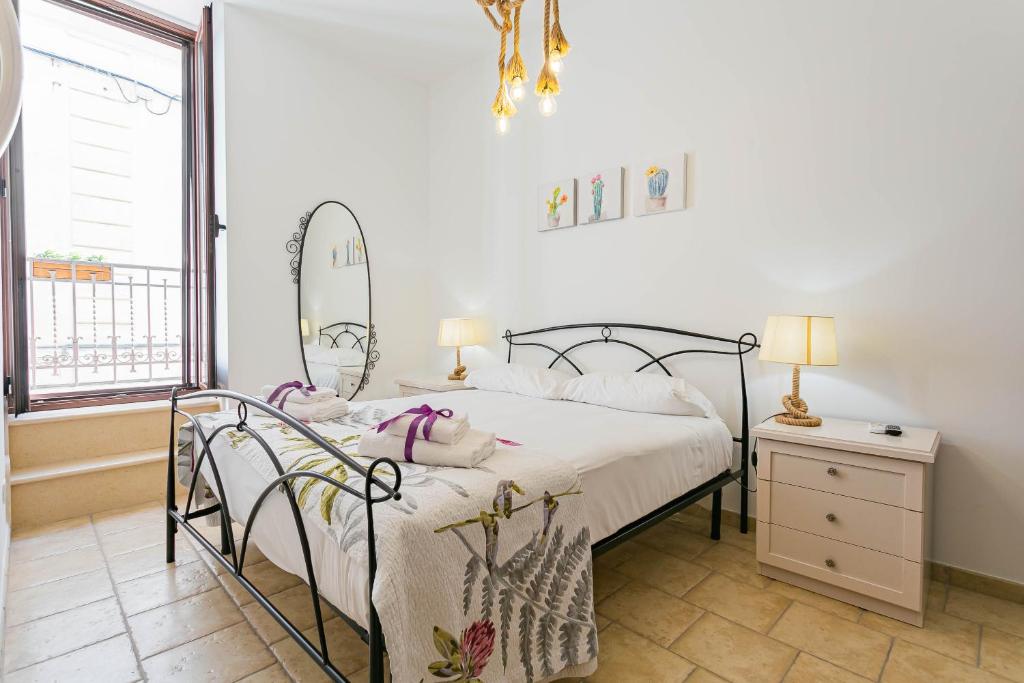 una camera con letto, specchio e finestra di Helios Rooms by Wonderful Italy a Conversano