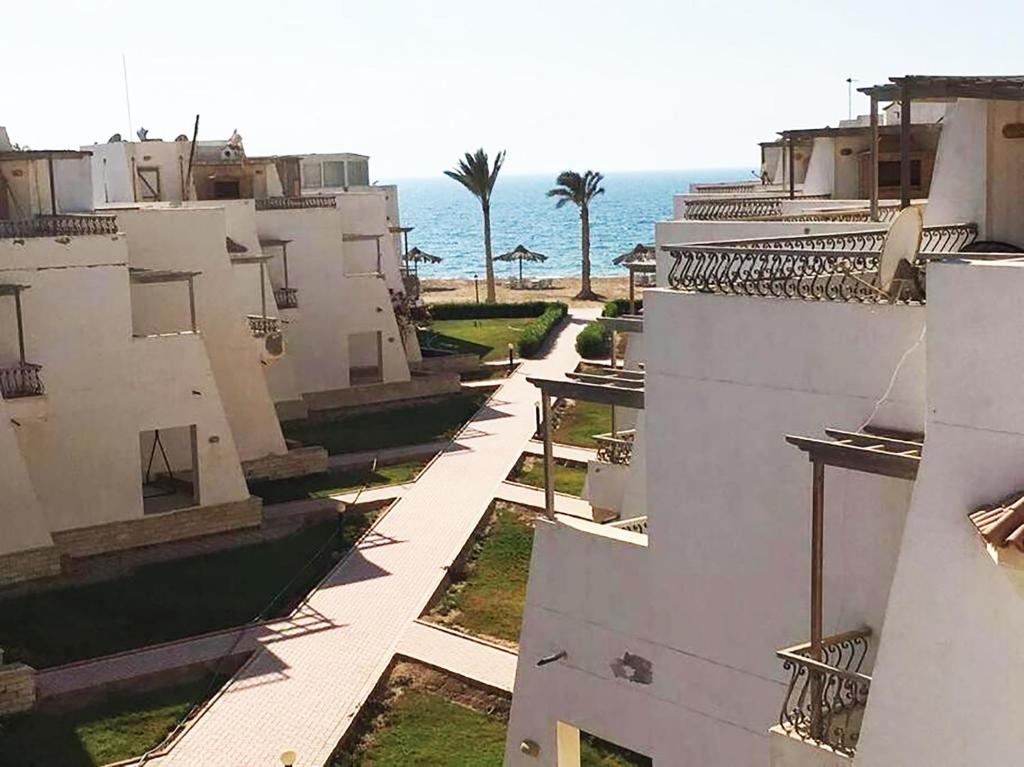 - une vue sur un bâtiment avec l'océan en arrière-plan dans l'établissement Concorde Royal Beach Village, Ras Sidr, South Sinai Villa 116, à Ras Sudr