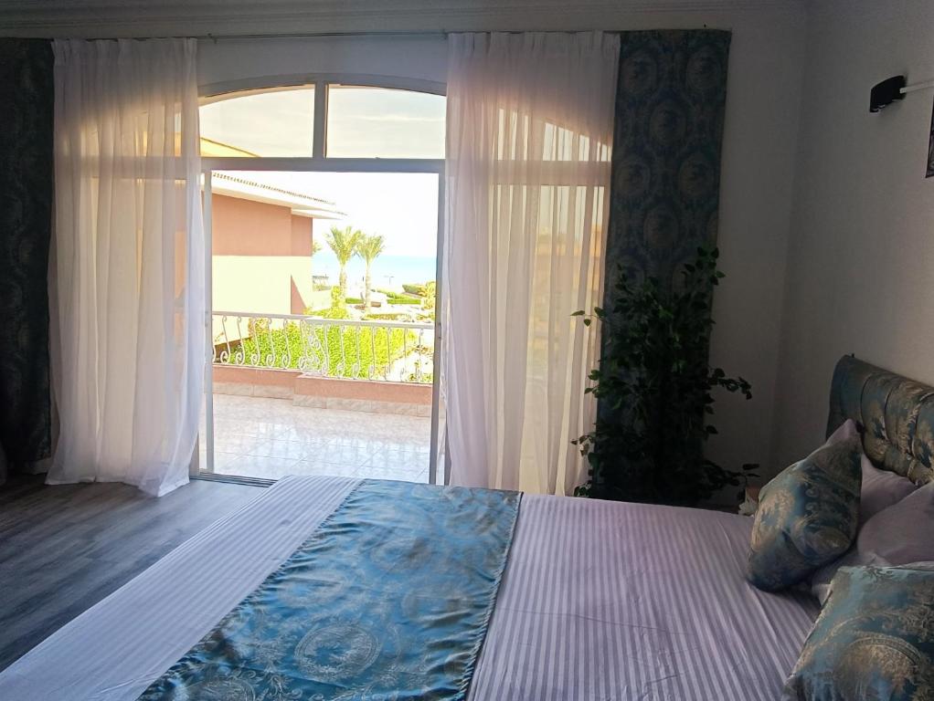 Un dormitorio con una cama y una ventana grande. en Vila Maia, en Hurghada