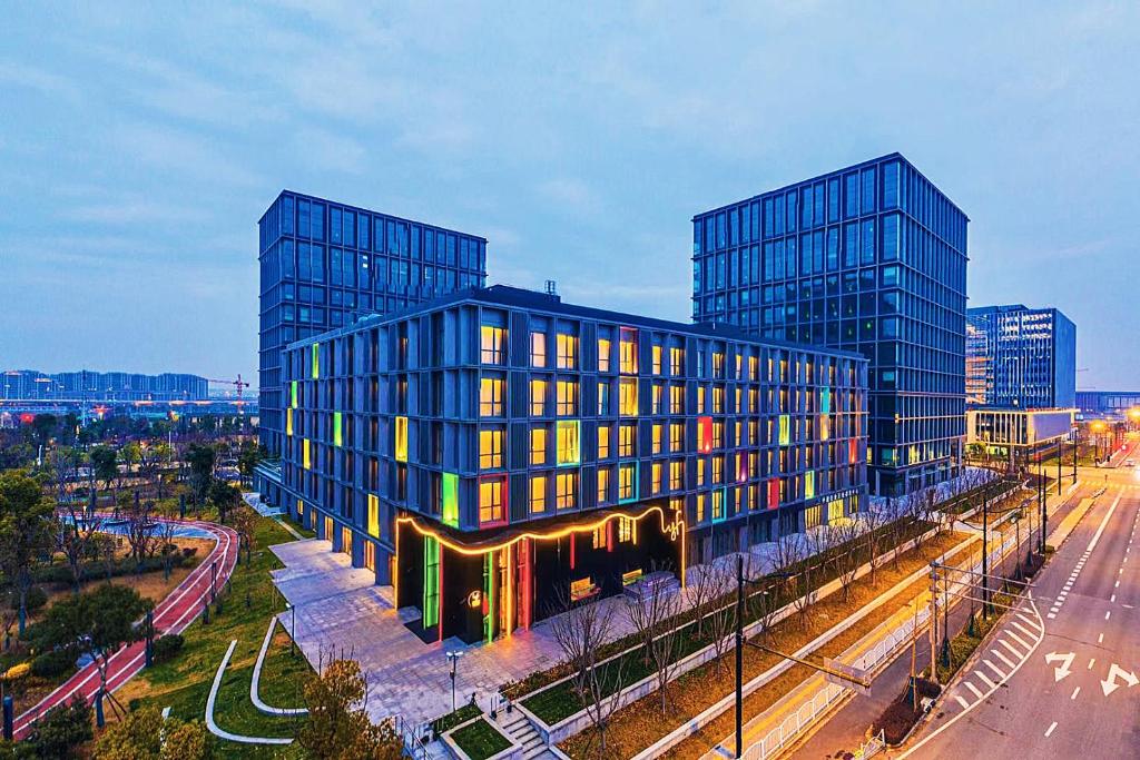 um grande edifício de vidro numa cidade com uma rua em lyf by Ascott Hongqiao Shanghai NECC em Xangai