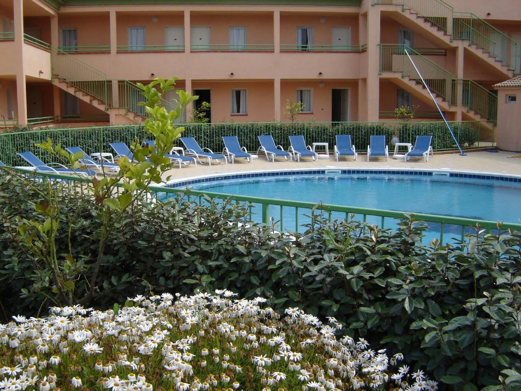 un hôtel avec piscine et chaises longues dans l'établissement Appartamento con 2 camere da letto a 200 m dalla spiaggia, à Linguizzetta