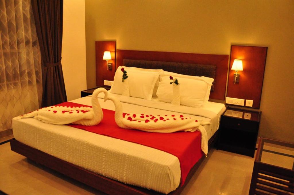 a hotel room with a bed with towels on it at Harbour Hotels in Pallipuram
