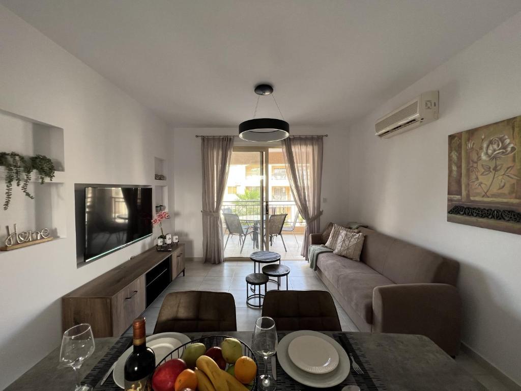 a living room with a couch and a table with fruit at Royal-Seacrest Paphos-Center VIP in Paphos City