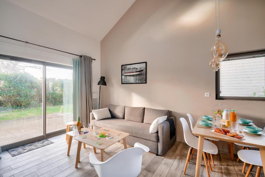 un salon avec un canapé et une table dans l'établissement Duplex pour 6 - 100m de la plage de Pors Carn, à Penmarcʼh
