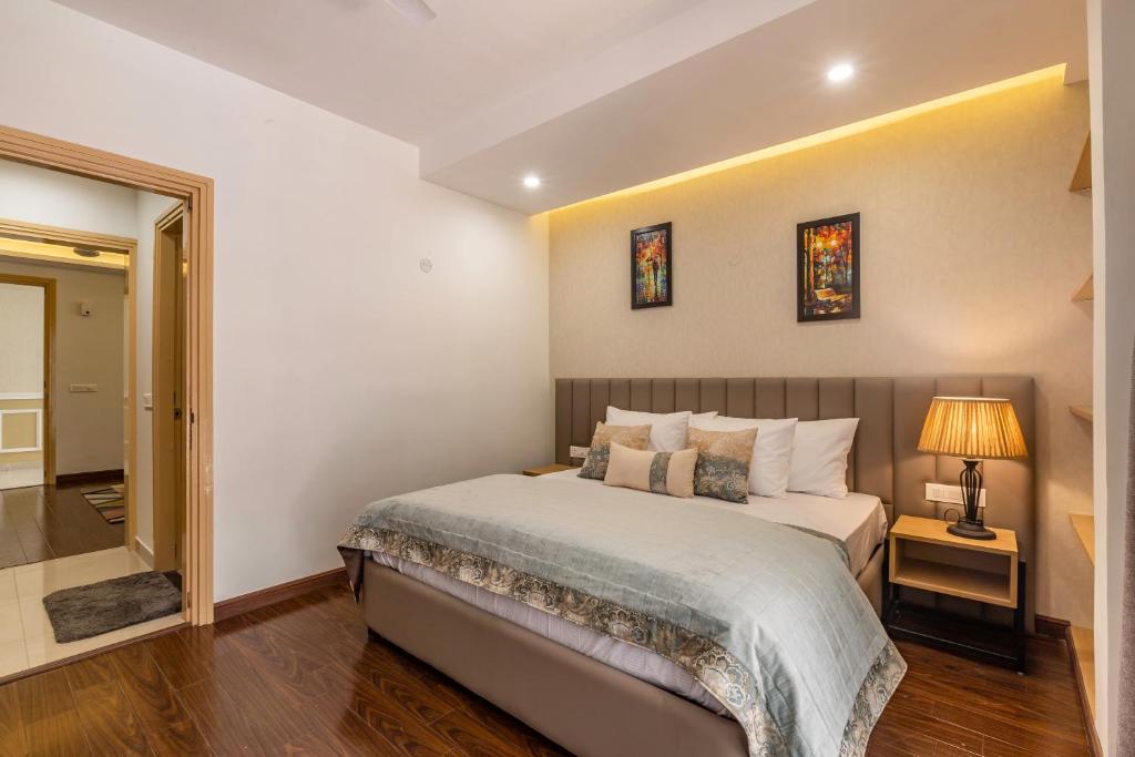 a bedroom with a bed and a lamp on a table at Pine Maderas by Embrace in Kasauli