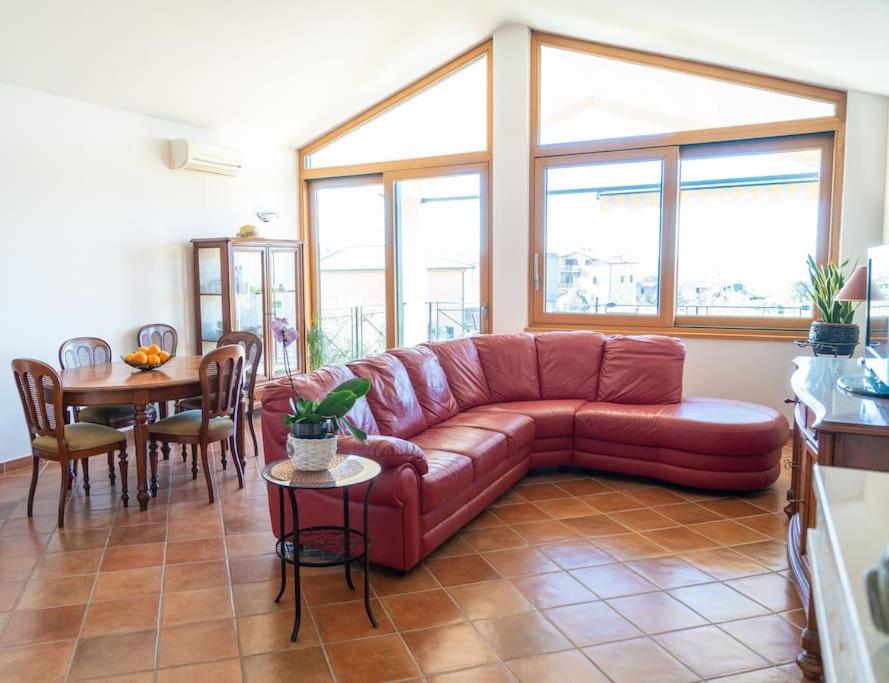 Alloggio turistico Il Tiglio في كانالي مونتيرانو: غرفة معيشة مع أريكة حمراء وطاولة