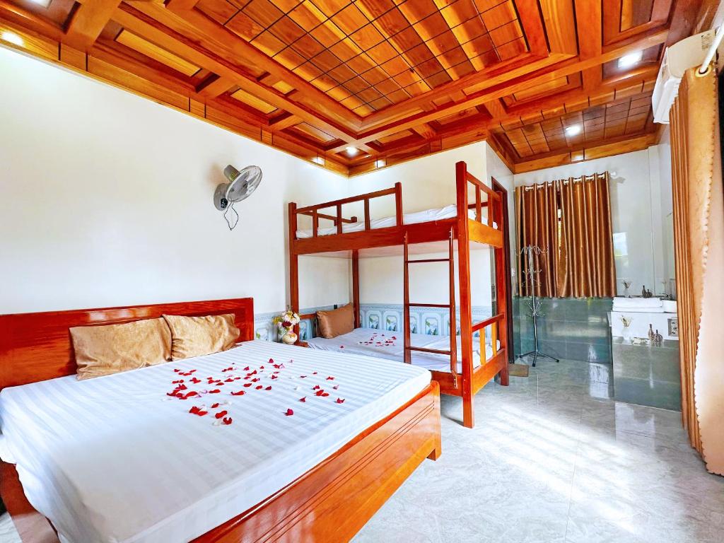 ein Schlafzimmer mit einem Bett mit roten Blumen darauf in der Unterkunft The Hillside Homes in Phong Nha