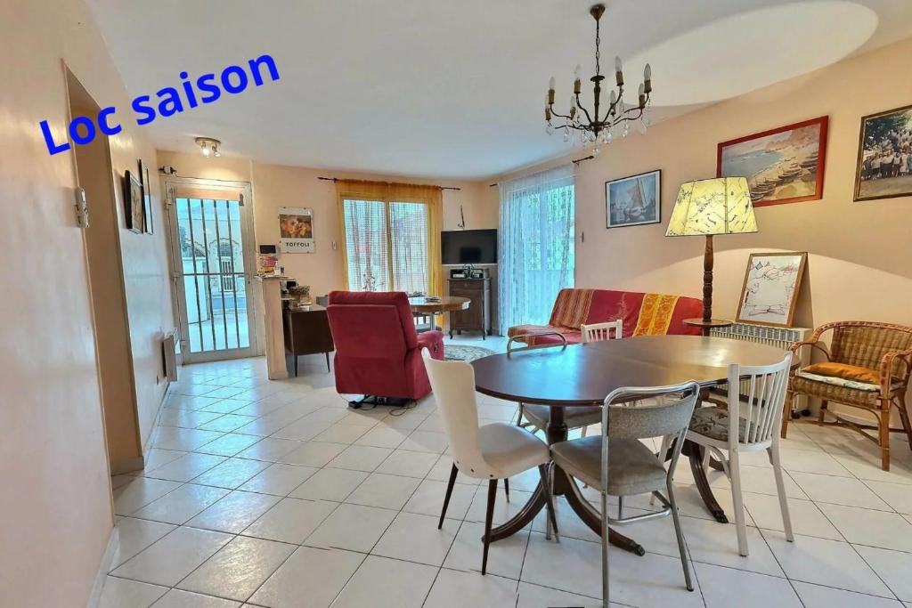 une salle à manger et un salon avec une table et des chaises dans l'établissement Isi, à Valras-Plage