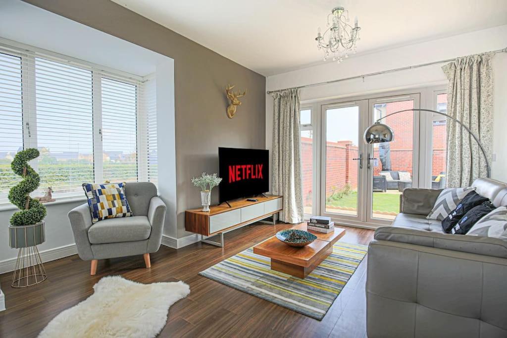 a living room with a couch and a tv at Luxury Detached House with Pool Table, Fast Wi-Fi, Smart TVs and Driveway Parking by Yoko Property in Milton Keynes