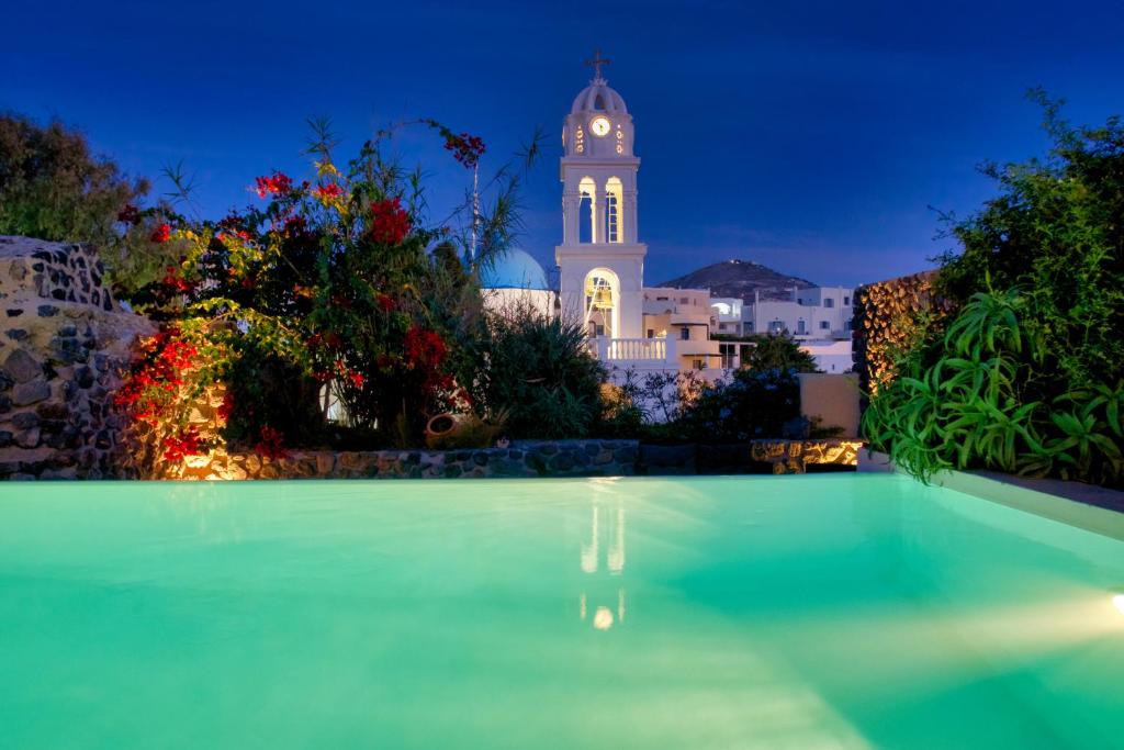 a building with a clock tower in the background at Santorini Heritage Villas in Megalochori