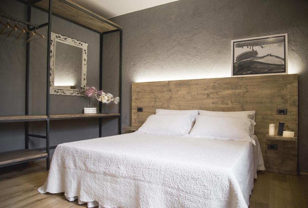 una camera da letto con un grande letto con lenzuola bianche di Il Giardino di Ortensia B&B a Bientina