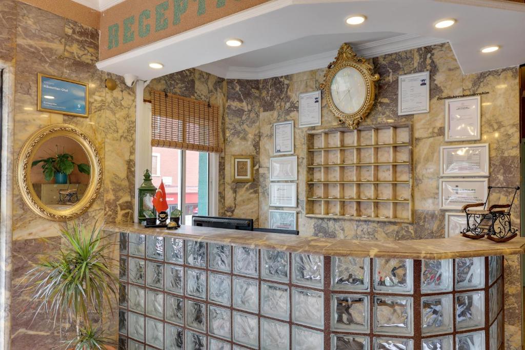 a lobby with a large stone wall with a mirror at Hikmethan Otel in Kusadası