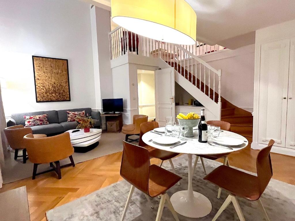 une salle à manger et un salon avec une table et des chaises dans l'établissement L'appartement Pierre Charron, à Paris