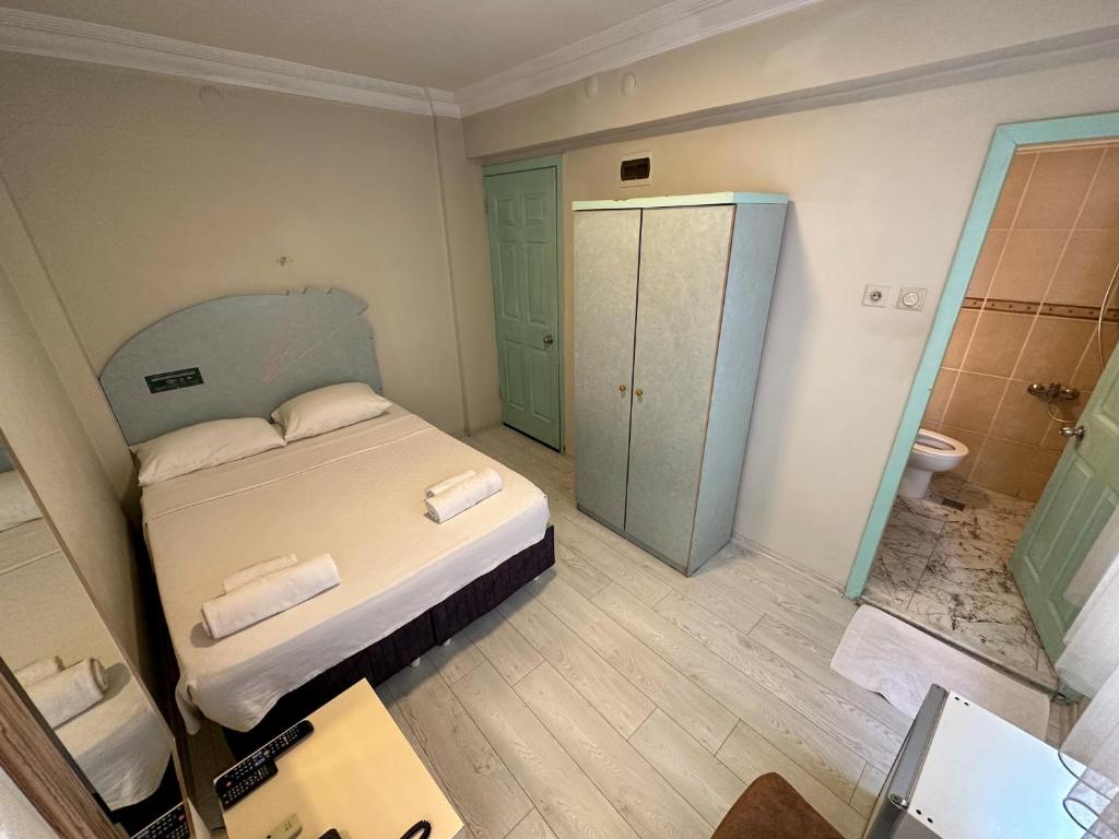 a bedroom with a bed and a bathroom with a toilet at Hikmethan Otel in Kusadası