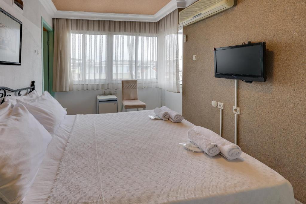 a hotel room with two towels on a bed at Hikmethan Otel in Kusadası