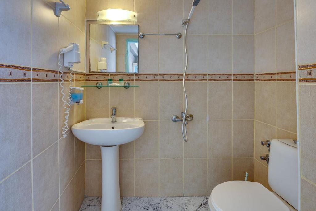 a bathroom with a sink and a toilet and a mirror at Hikmethan Otel in Kusadası