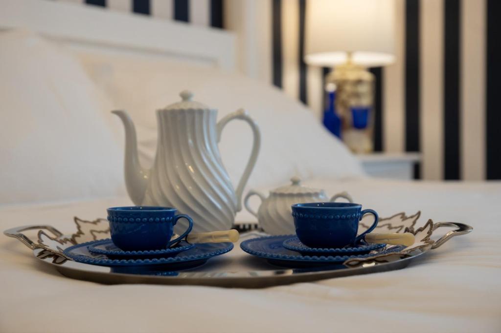 a plate with two cups and a pitcher on a table at Le residenze del capitano in Bari