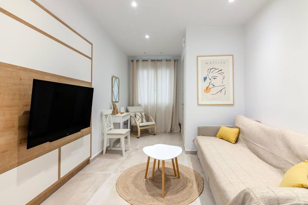 a living room with a couch and a flat screen tv at The 626 Park Apartment in Heraklio