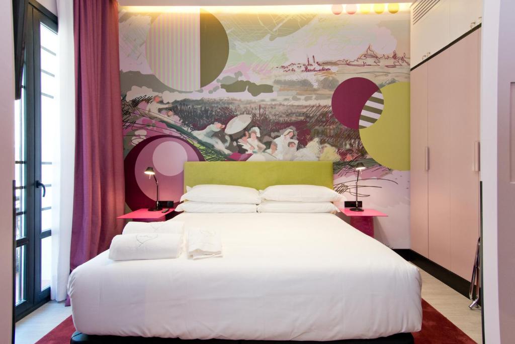 1 dormitorio con 1 cama blanca grande y una pintura en la pared en Amor de Dios 17 Boutique Apartments, en Madrid