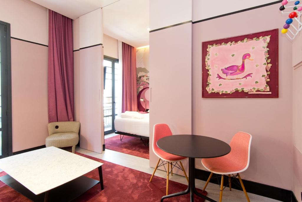 una sala de estar con una mesa y sillas en Amor de Dios 17 Boutique Apartments, en Madrid