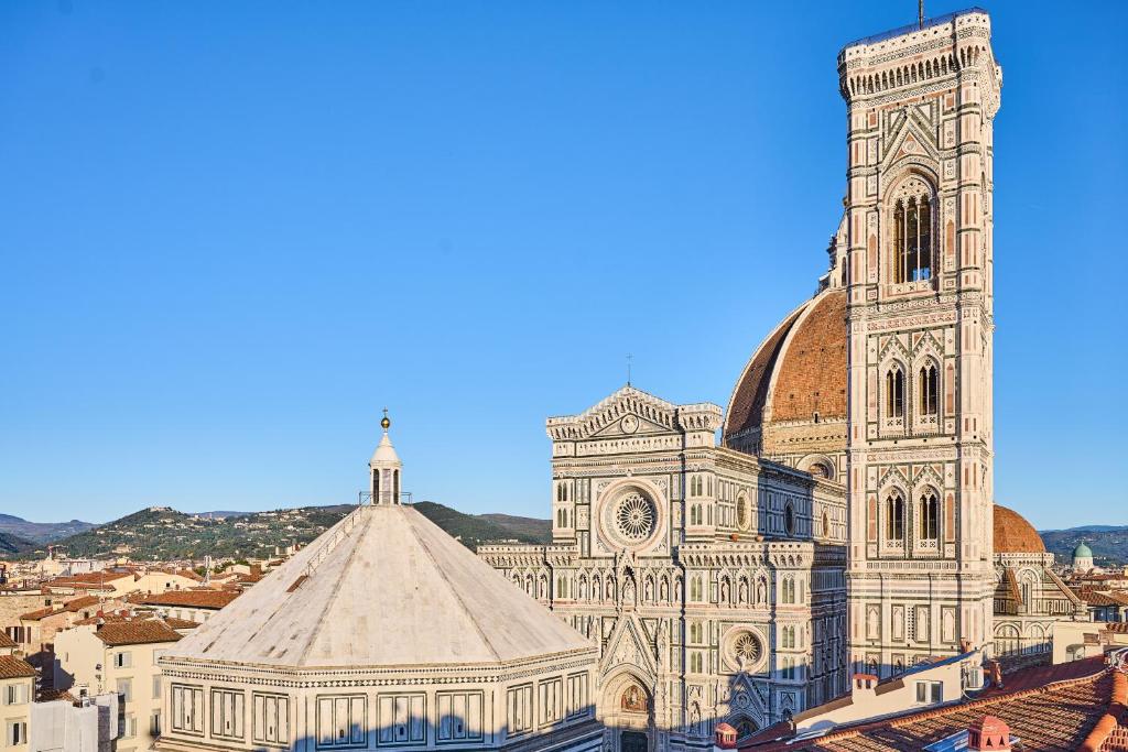 un grand bâtiment avec une tour d'horloge dans une ville dans l'établissement Duomo Luxury Florence, à Florence