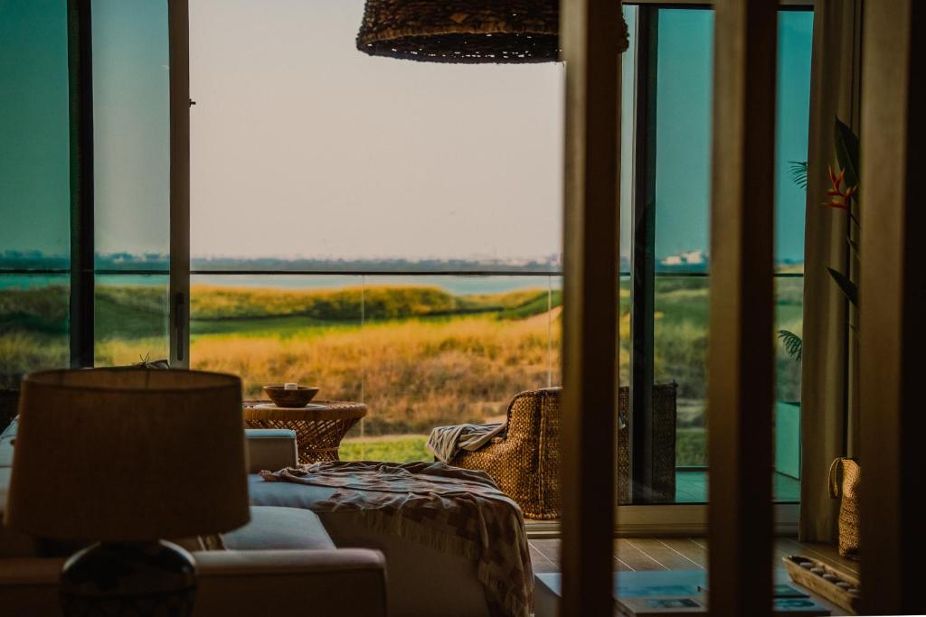 a room with a window with a view of a field at Private Pool & Beach At Your Doorstep in Abu Dhabi