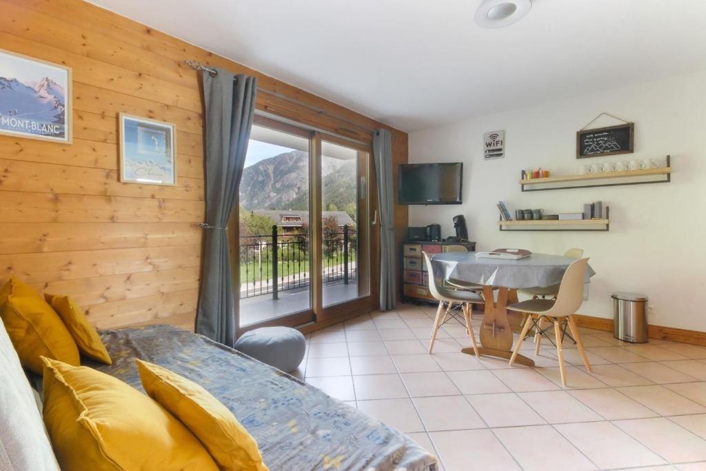Habitación con cama, mesa y balcón. en Albertine - Centre de Chamonix - Garage - Mountain Views!, en Chamonix-Mont-Blanc