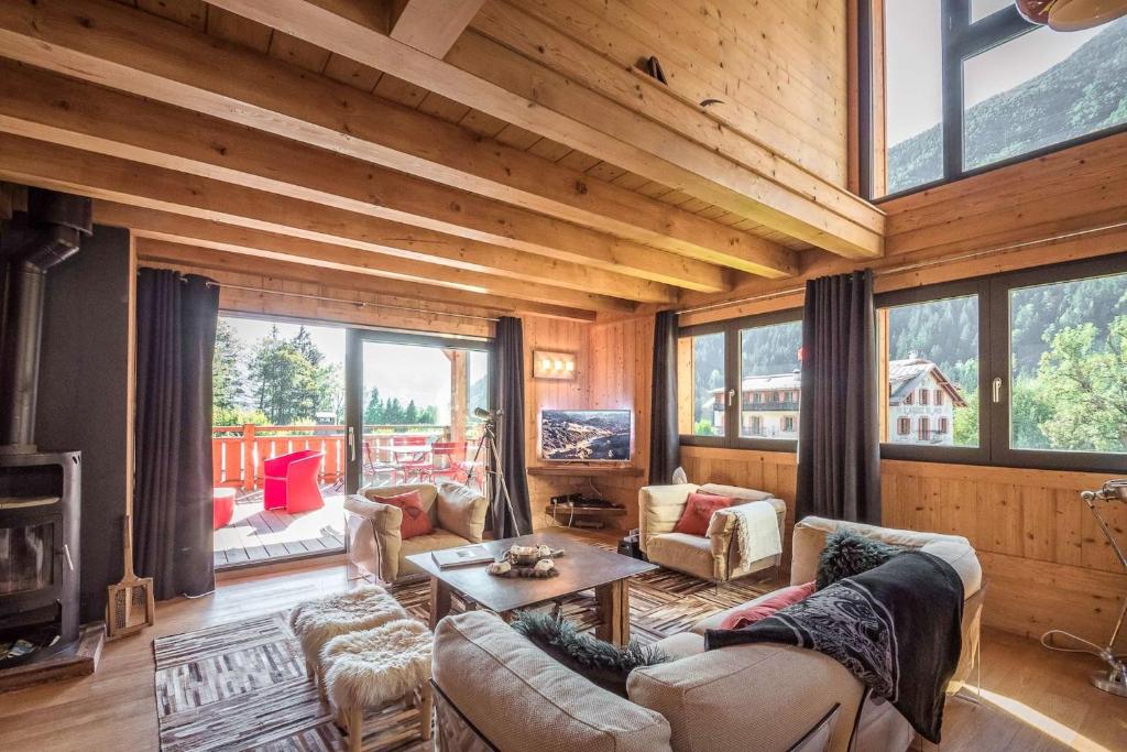 a living room filled with furniture and a large window at L'écrin des Bossons in Chamonix-Mont-Blanc