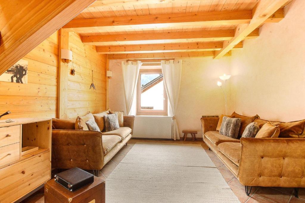 un salon avec deux canapés et une fenêtre dans l'établissement L'Ecrin des Pècles - Centrale - Rénové - Immense Terrasse Face au Mont-Blanc, à Chamonix-Mont-Blanc