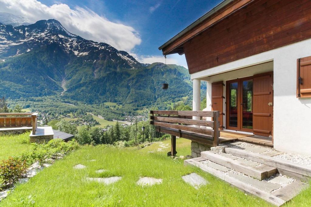 een gebouw met een bank en uitzicht op een berg bij The Historic Chalet Les Allognes Mont-Blanc views in Les Trabets