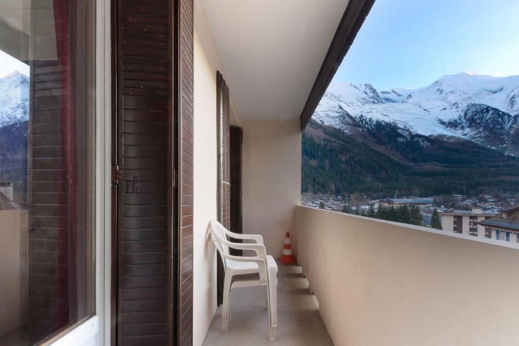 Les Pècles Mt Blanc - Chamonix Center في شامونيه مون بلان: كرسي أبيض جالس على شرفة مطلة على الجبال